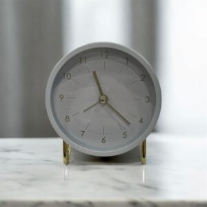 réveil blanc sur pied doré
